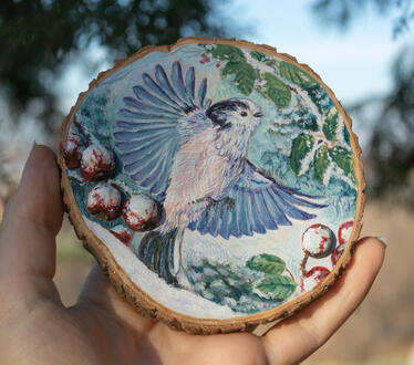Small bird in a winter scenery. Acrylic on wood slice 10x10cm
